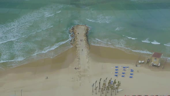 Bird eye view of the beach and sea with rocky pier