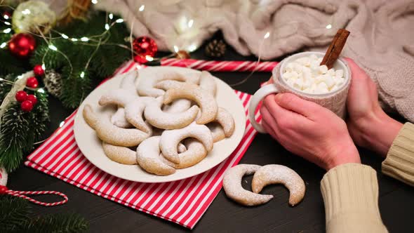 Woman Holding Cup of Cocoa with Marshmallow and Traditional Vanillekipferl Vanilla Kipferl Cookies