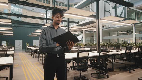 Young Indian Latin Manager Male Business Man Employee Checking Document Folder Inspecting Financial