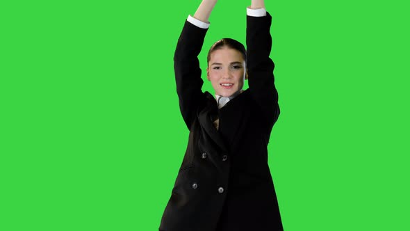 Young Woman in Office Suit Walks Dancing Raising Her Arms on a Green Screen Chroma Key