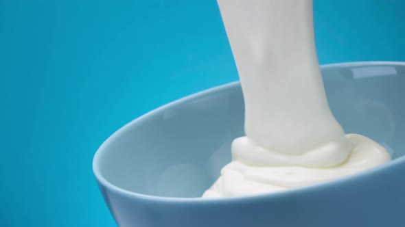 Flowing Fresh Greek Yogurt on Blue Background