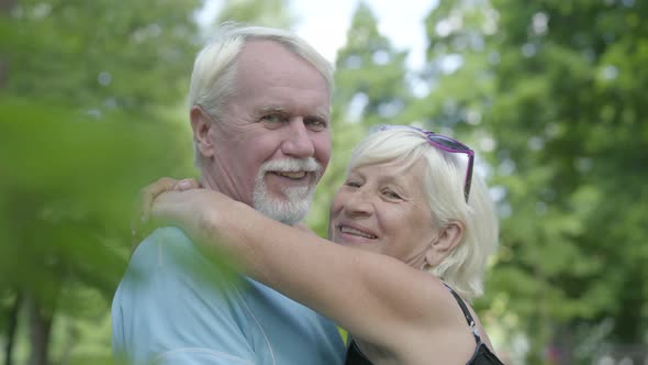 Mature Couple Kissing and Looking in the Camera Smiling