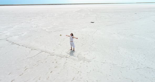 Happy young girl standing on a dry salt lake