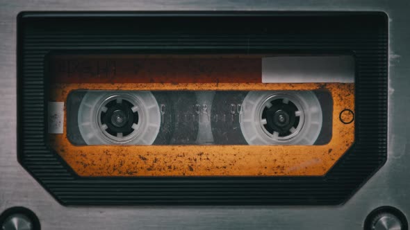 Vintage Yellow Audio Cassette Tape Rotates in Deck of an Old Tape Recorder