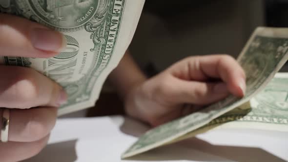 Closeup of Woman Counting Her Money on Kitchen at Night