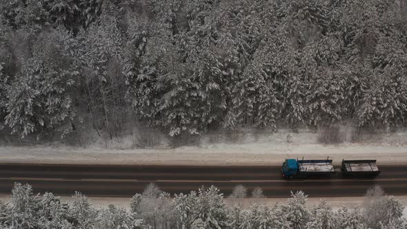 A Car Driving Along the Road Against the Backdrop of Beautiful Winter Landscapes on a Cloudy Day