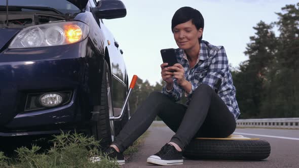 Girl Changing a Tire Outdoors