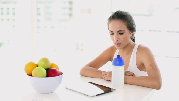 Beautiful Young Woman Taking A Drink After Working