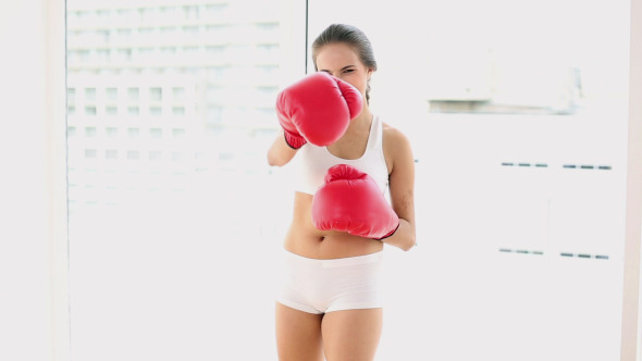 Beautiful Young Woman Punching With Boxing Gloves