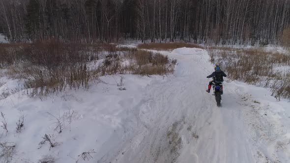 Aerial view of Racer motorcycle rides on motocross snowy track in winter 04