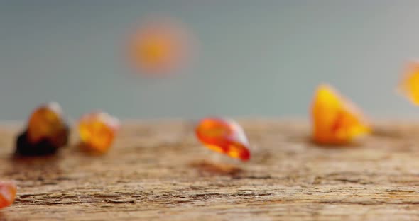 Natural Amber Stone Falling on a Wooden Plate