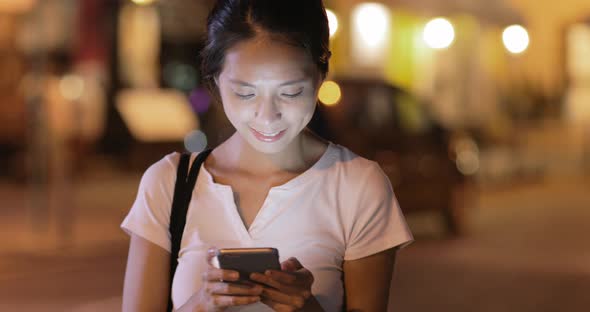 Woman using mobile phone at night