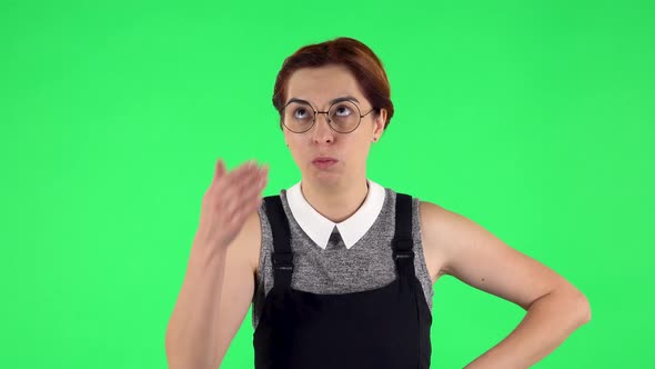 Portrait of Funny Girl in Round Glasses Is Upset, Waving Her Hands in Indignation, Shrugging