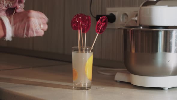 Chef Putting Handmade Lollipops on the Wand in a Cup