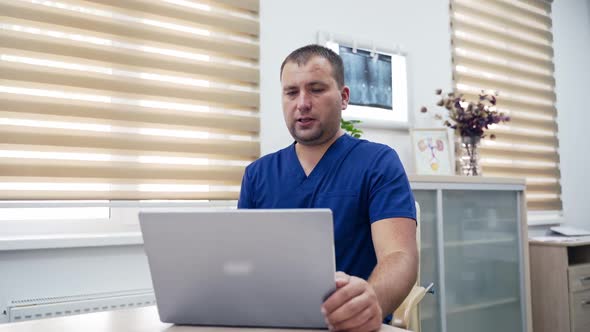 Telemedicine. Medical specialist sitting at his desk and consulting patient via video call in office