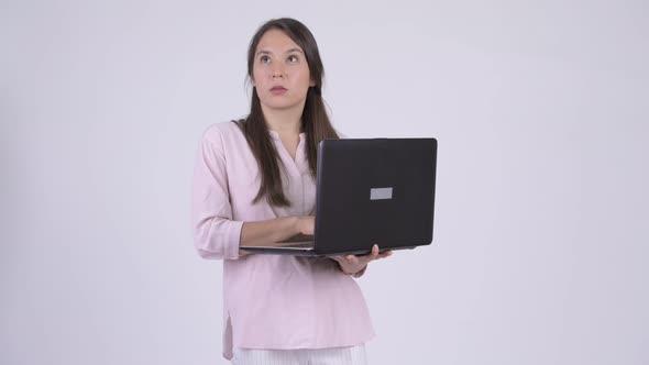 Young Happy Multi-ethnic Businesswoman Thinking While Using Laptop