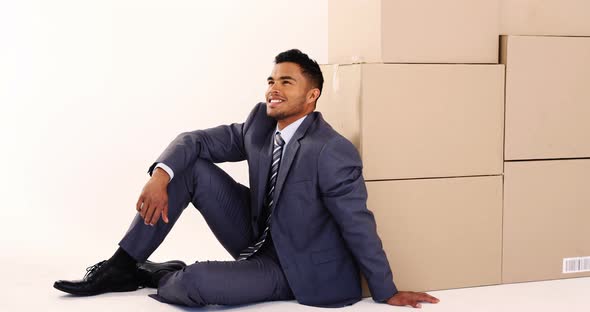 Businessman leaning on cardboard boxes