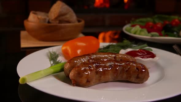 Plate with Grilled Sausages Near Burning Fireplace