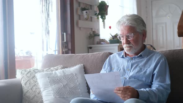 Sad elderly man reading health insurance deal closing looking and reading the medical results