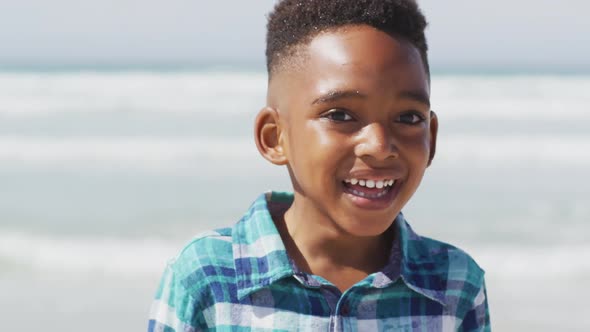 Portrait of happy african american boy on sunny beach