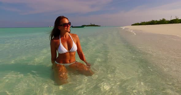 Sexy fun woman travelling spending quality time on beach on summer white sandy and blue 4K background