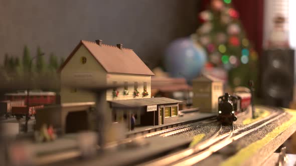 Toy Locomotive Moving Through Model Train Station.