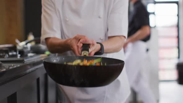 Caucasian female chef teaching diverse group preparing dishes and smiling