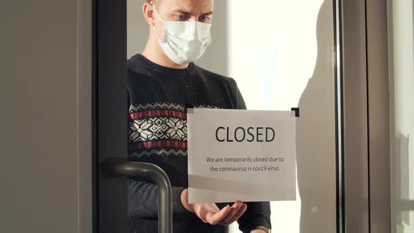 A Handsome Masked Man Walks Up to the Glass Door and Rips Off the 'Closed' Sign