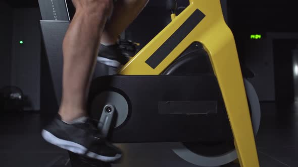 Man Training on a Spin Bike Performs Aerobic Endurance Training on the Simulators in the Gym Cycle