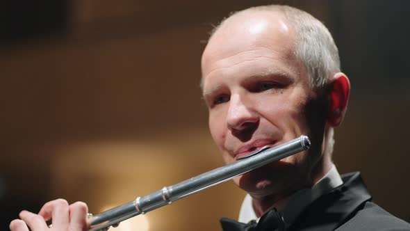 Portrait of Aged Flutist in Opera House Closeup View of Male Face with Flute Classic Music Concert