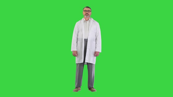 Mature Doctor with Folded Arms Standing on a Green Screen Chroma Key