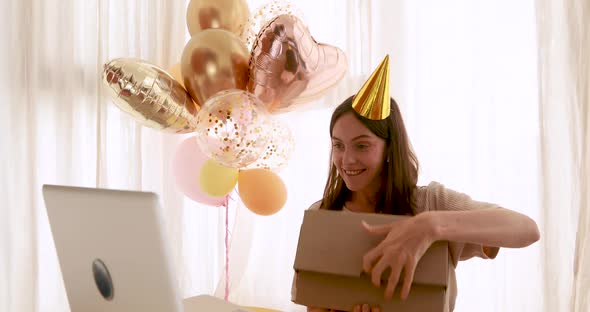 Woman Opens Gift in Front of Birthday Laptop