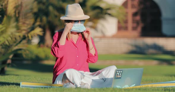 Young Beautiful Woman Puts on Medical Mask Protecting Her Face During COVID-19