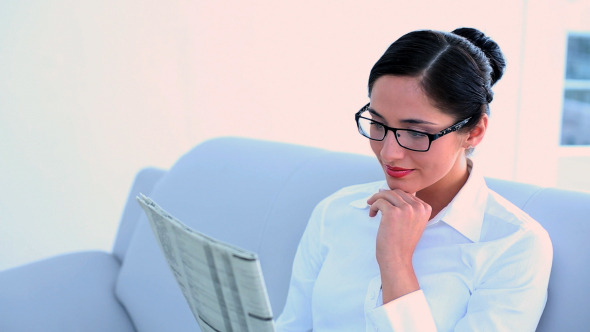 Attractive Businesswoman Sitting On Couch Reading