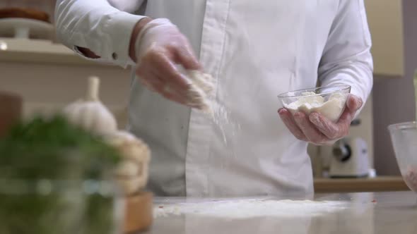 Flour falling from hand. Chef pouring and sifting meal for cooking preparation.