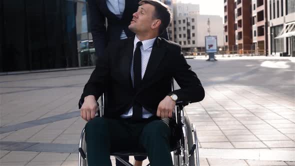 Businesswoman Helping Cripple Businessman After Meeting Outdoor