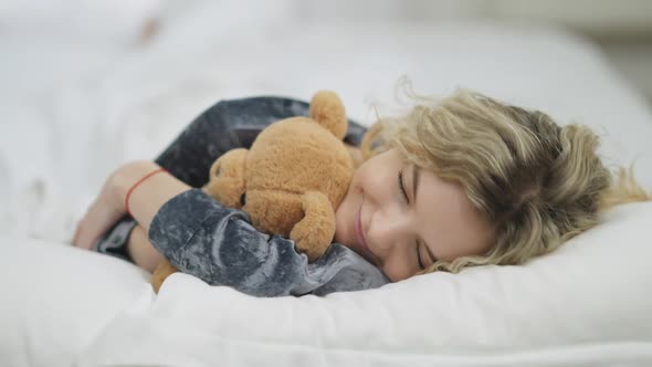 Closeup Portrait of Happy Relaxed Smiling Woman Sleeping Lying in White Comfortable Cozy Bed in the