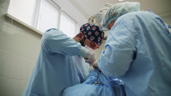 a male surgeon performs an operation