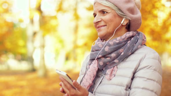 Old Woman with Smartphone and Earphones in Autumn 18