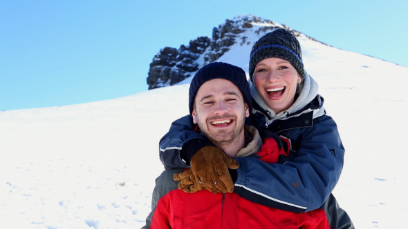 Smiling Man Giving His Girlfriend A Piggy Back