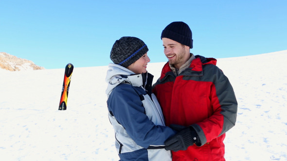 Happy Couple Standing Outside In The Snow