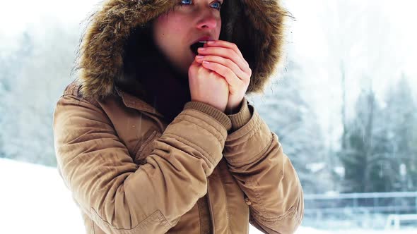 Woman in fur jacket warming her hands