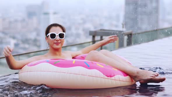 Asian young woman relaxing in swimming pool at luxury hotel