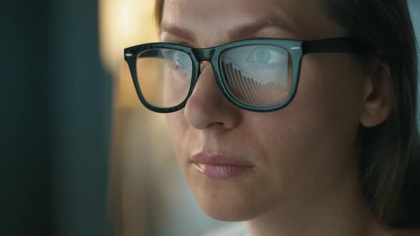 Woman in Glasses Looking on the Monitor and and Working with Charts and Analytics