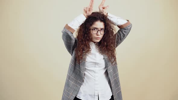 The Angry Angry Young Woman with Her Hands Above Her Head Emits Bull's Horns to Start a Fight