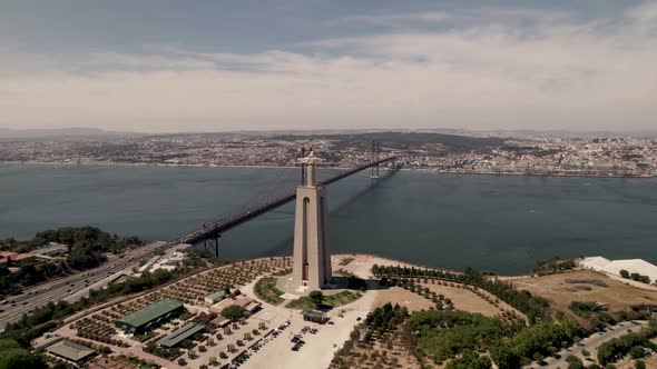 Panoramic aerial wide shot of pedestal monument of Christ the King overlooking at Lisbon city.
