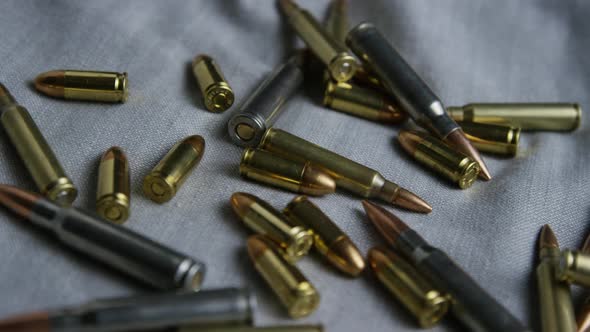 Cinematic rotating shot of bullets on a fabric surface - BULLETS 099