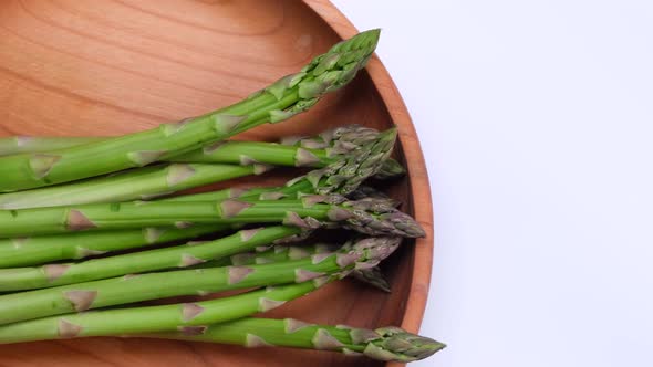 Rotating Green Fresh Asparagus on Wooden Background Plate  Healthy Food Concept