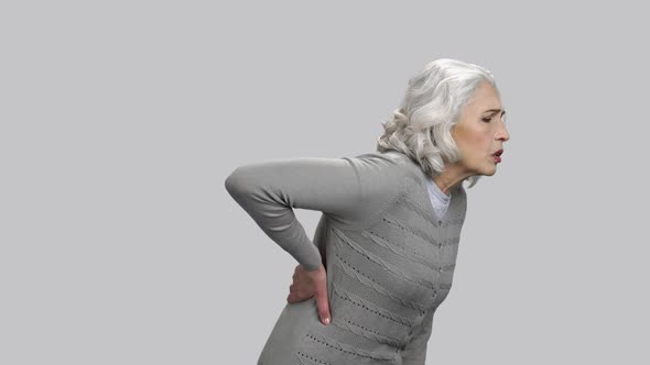 Old Lady Thin Having Back Pain and Toucing It with Hand