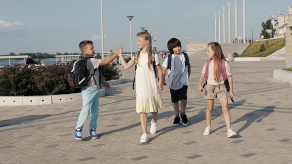 Infant school kids walking to school with backpacks and